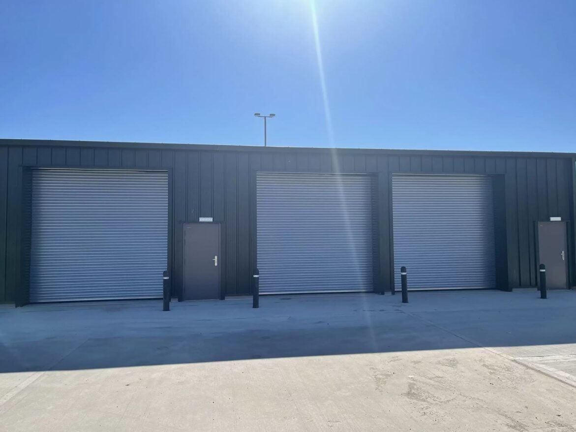 A cold rolled steel building with multiple roller shutter doors.