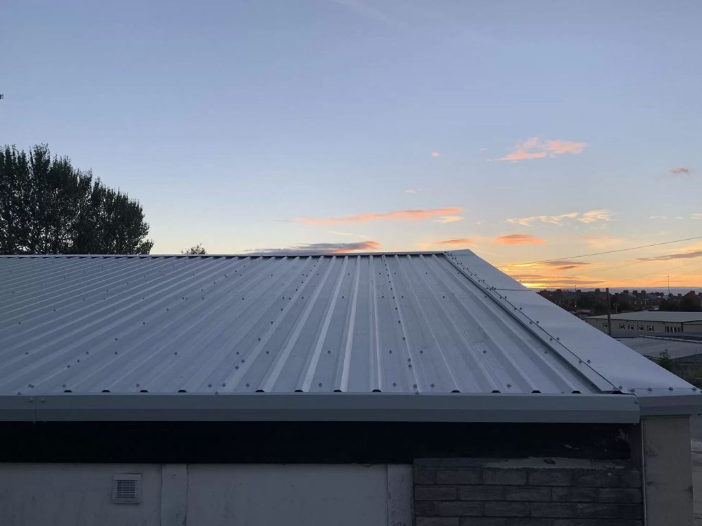 Close-up of a green corrugated steel roof on a Hamilton Steel garage building at sunset