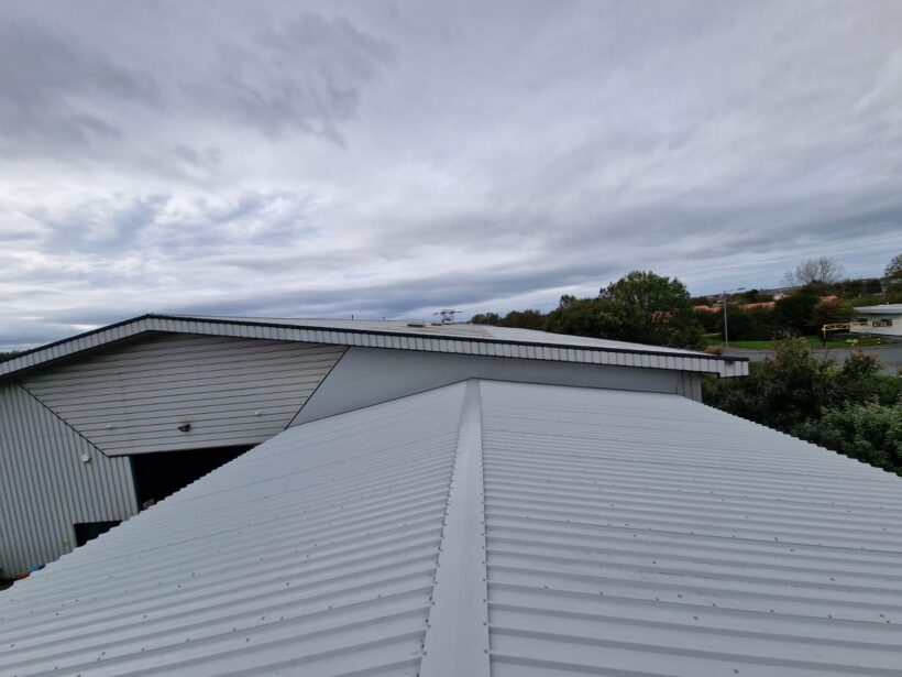 Photograph showing grey cladding and flashings against existing building