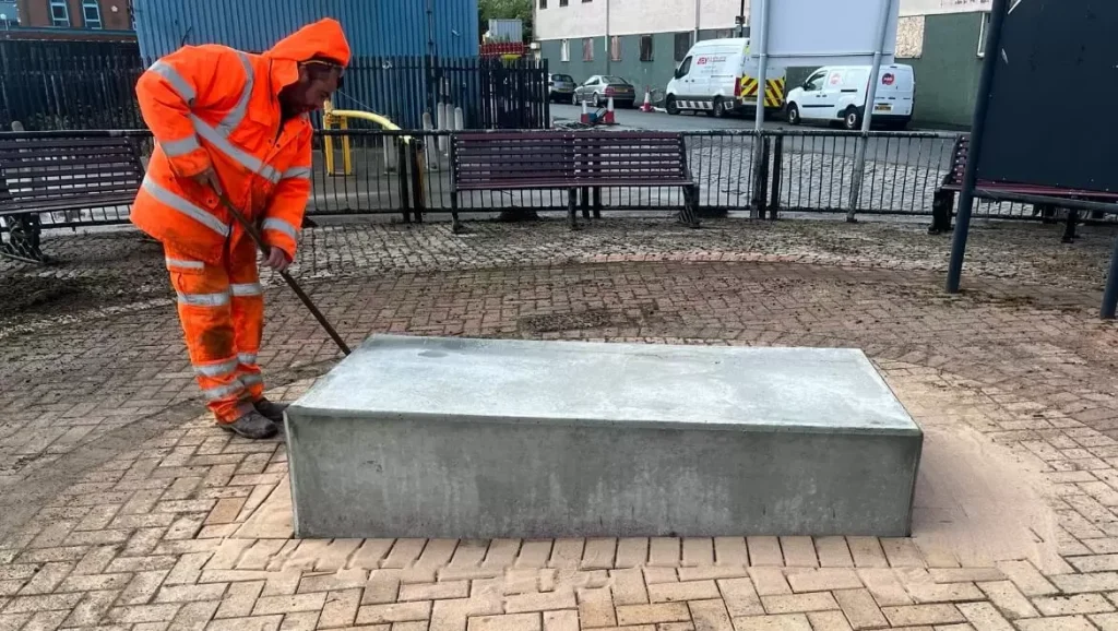 Groundworker finishing the cast concrete plinth for the Herring Girl statue in North Shields