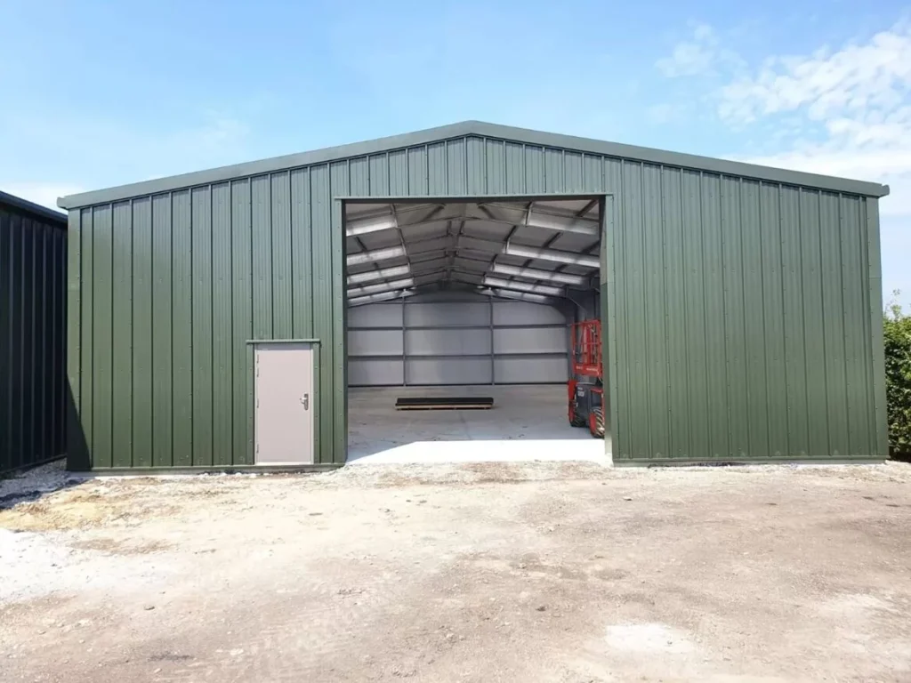 Completed green clad agricultural steel building with a wide open bay at Lewhurst Farm
