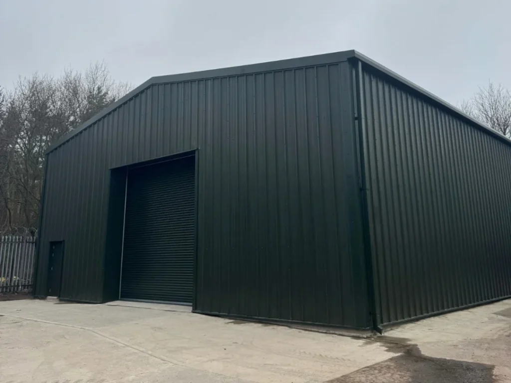 Completed dark green clad steel building with roller shutter door for The Metal Drum Company
