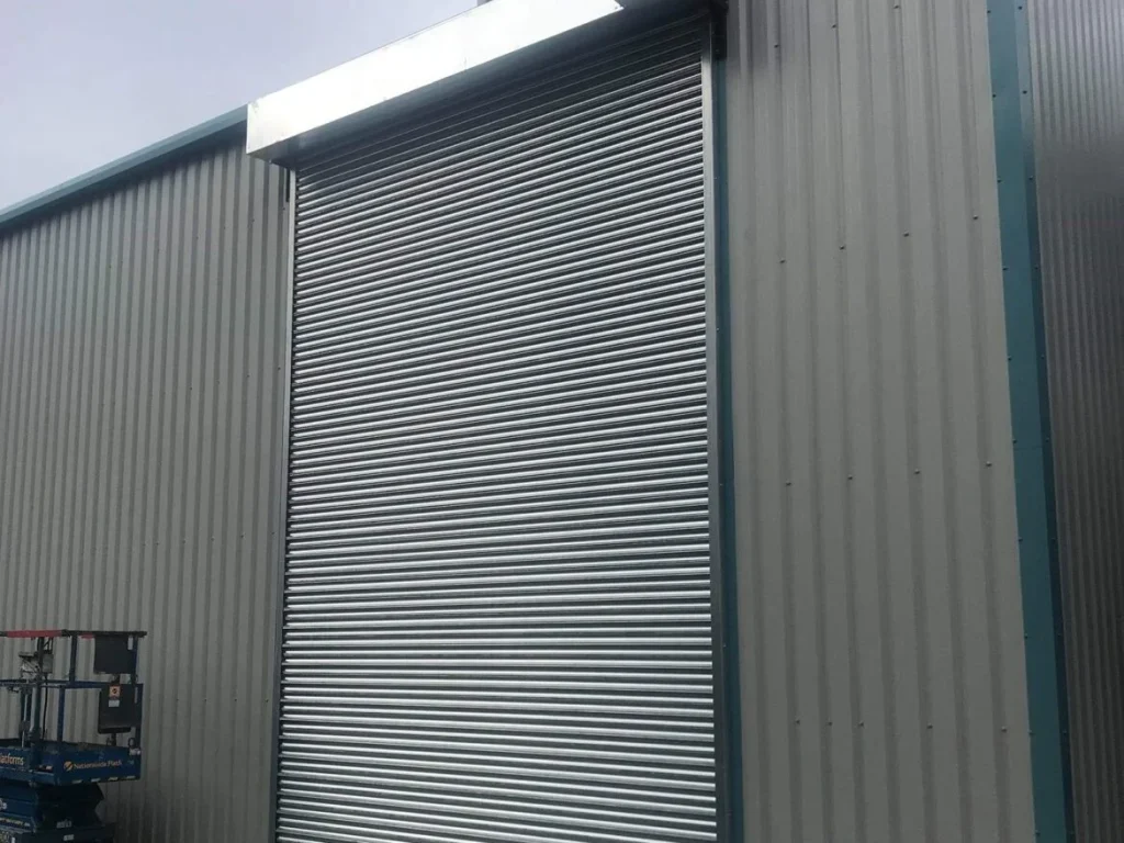 Tall galvanised roller shutter door fitted into the clad elevation at Oil Salvage Ltd