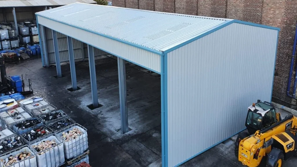 Open sided steel canopy building with blue trim over the storage yard at Oil Salvage Ltd