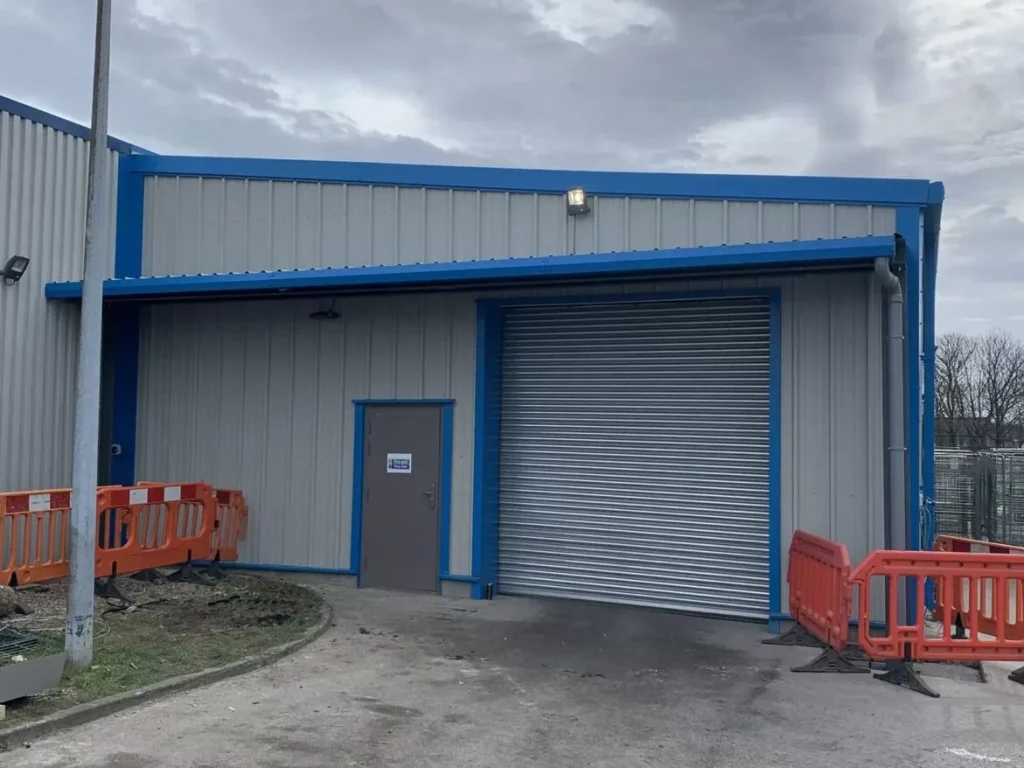 New steel canopy and roller shutter entrance in blue and grey cladding at Simply Food Solutions Ltd
