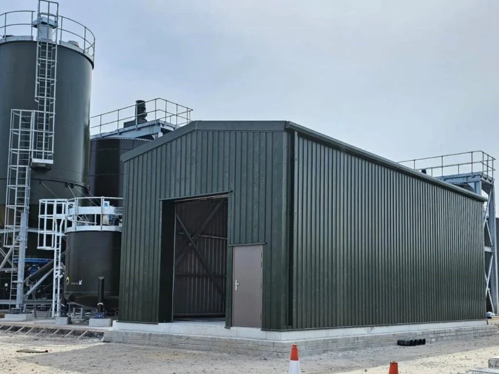 Completed dark green clad steel building beside the process tanks at South Crofty Mine