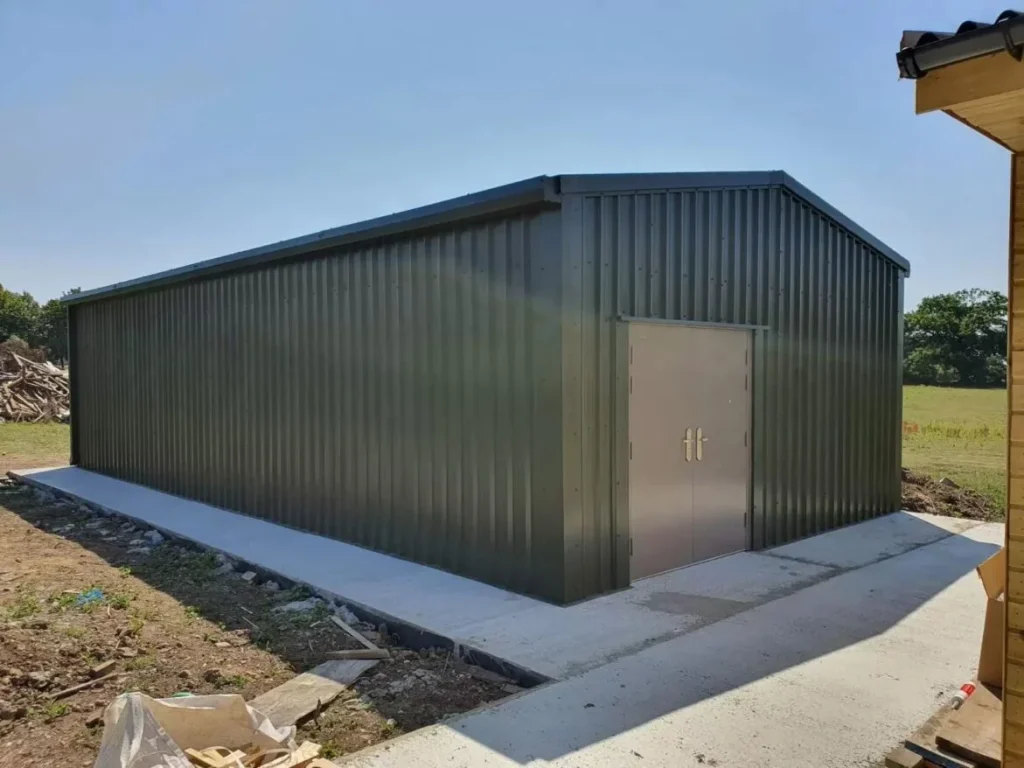 Green clad special offer steel building with double personnel doors and concrete apron