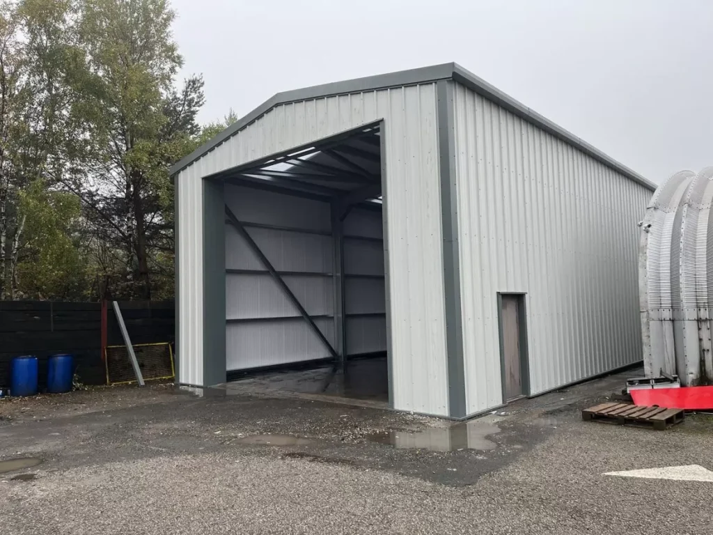 Completed grey clad steel building with tall open bay and lined internal walls for Stanley Travel