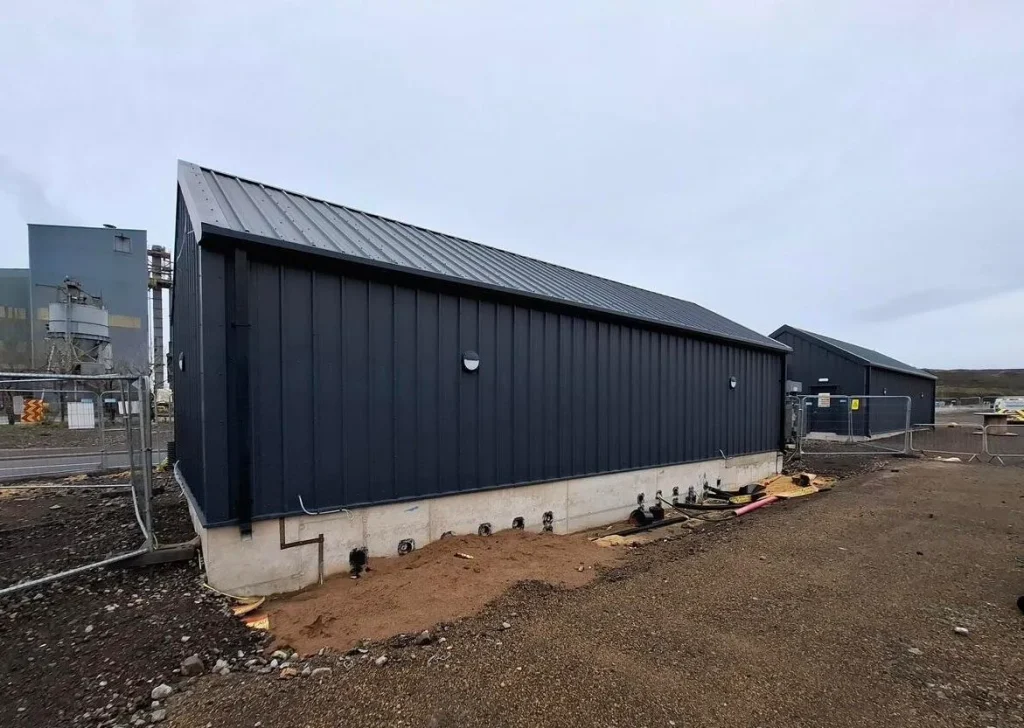 Side elevation of the completed Teesworks LV building with anthracite cladding on a concrete plinth