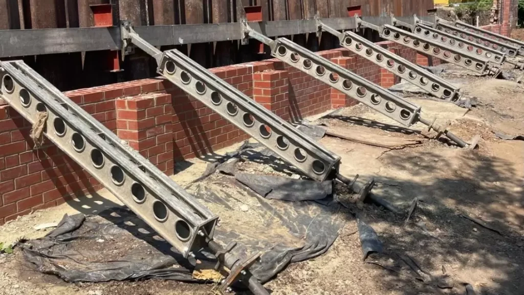 Sheet piled excavation supported by hydraulic props alongside brick foundations on the Thirteen Group civil engineering scheme