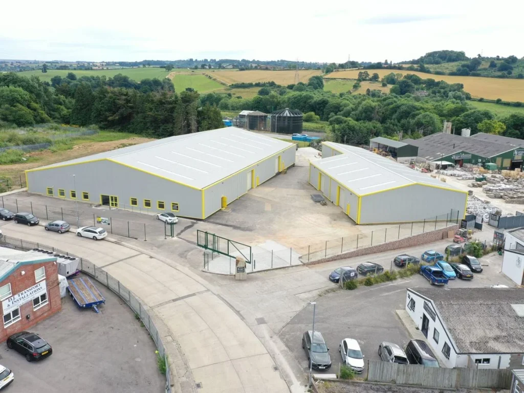 Aerial view of two refurbished industrial units in Yeovil with new grey roof sheeting and yellow trim