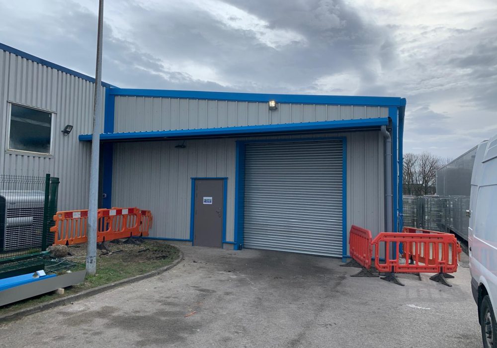 A durable steel frame canopy installed over an industrial building entrance to provide weather protection and shelter.