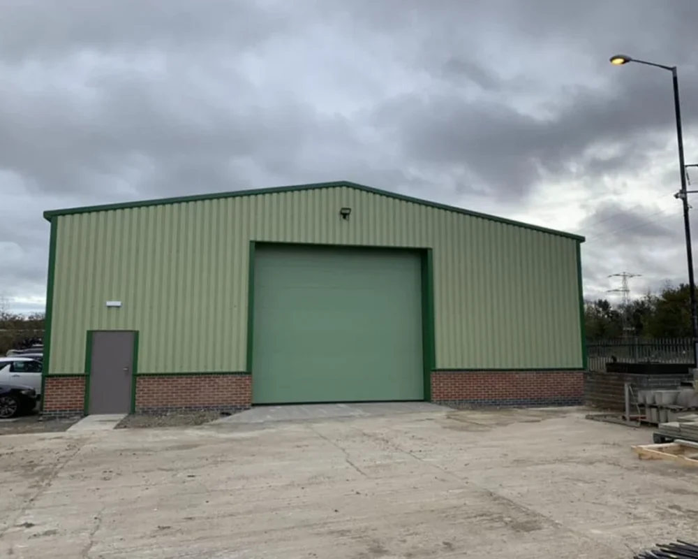 Completed green-clad steel building for Fred Mence Construction Ltd