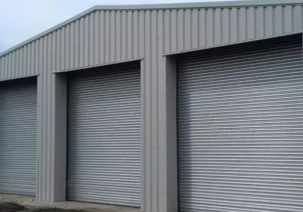 Grey steel storage building with three roller shutter doors