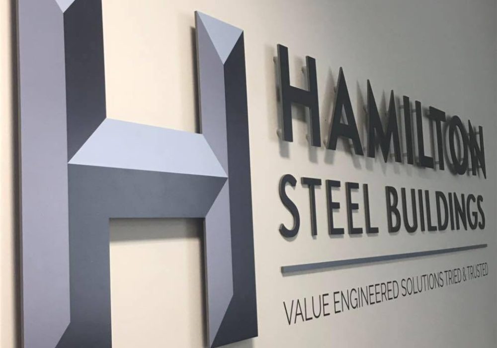 Hamilton Steel Buildings company logo displayed on the office wall