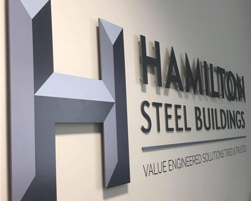 Hamilton Steel Buildings company logo displayed on the office wall