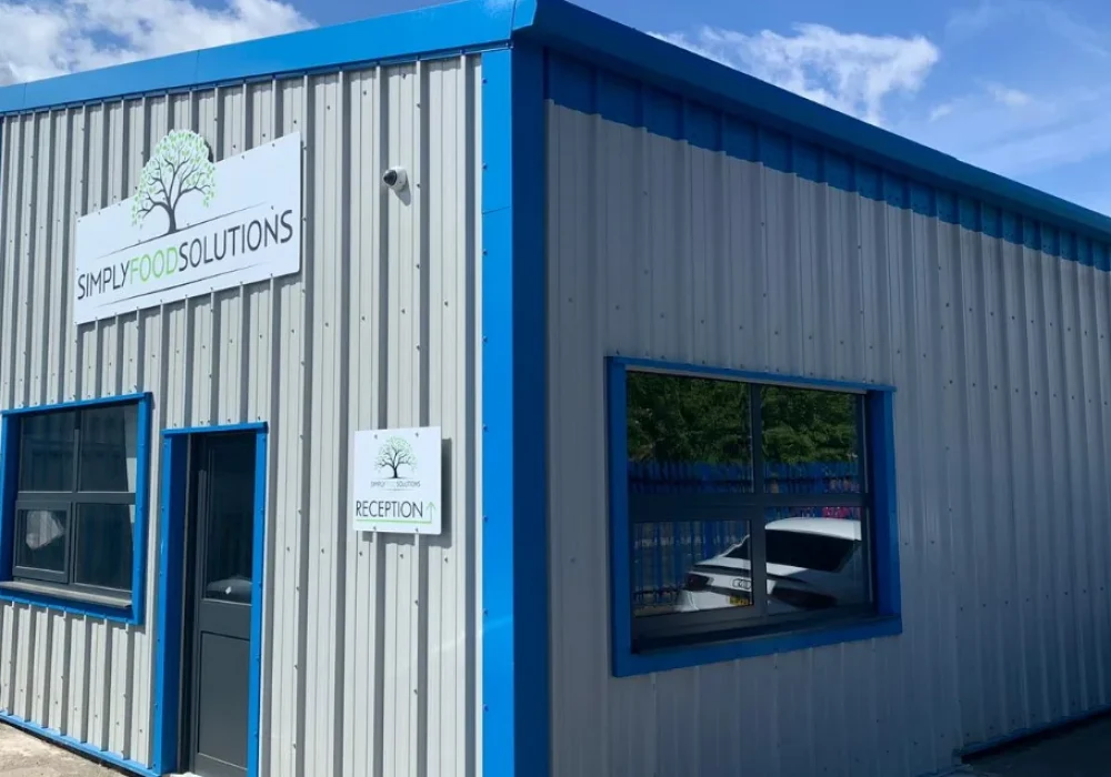 Completed steel building extension with Simply Food Solutions signage above the reception entrance