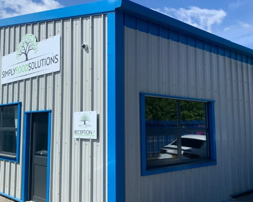 Completed steel building extension with Simply Food Solutions signage above the reception entrance