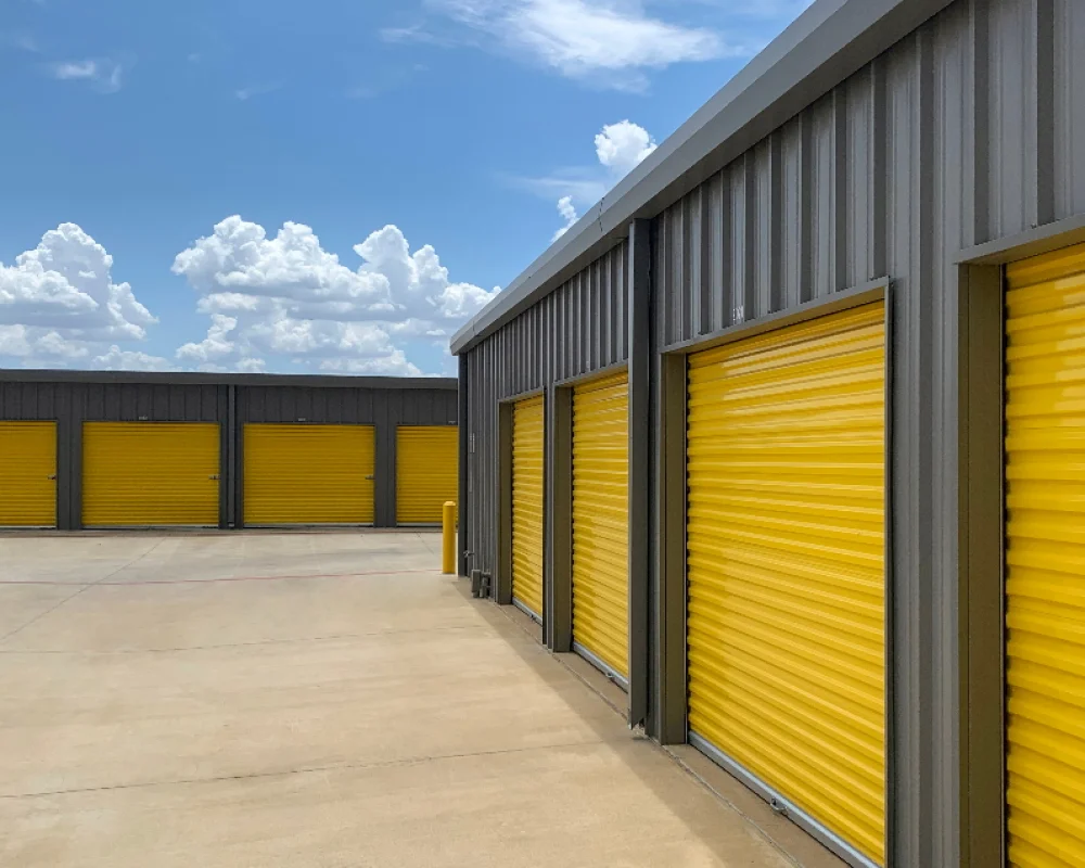 Steel storage buildings with yellow shutter doors.