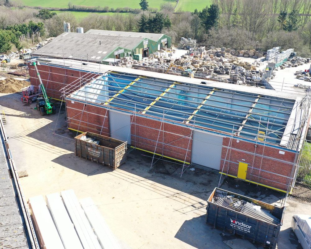 Steel building refurbishment in progress with new roof panels and rooflights being fitted