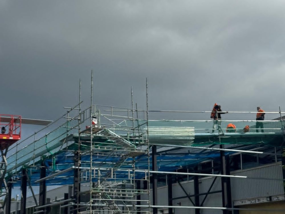 Hamilton Steel team installing roof sheeting from scaffolding on a construction site