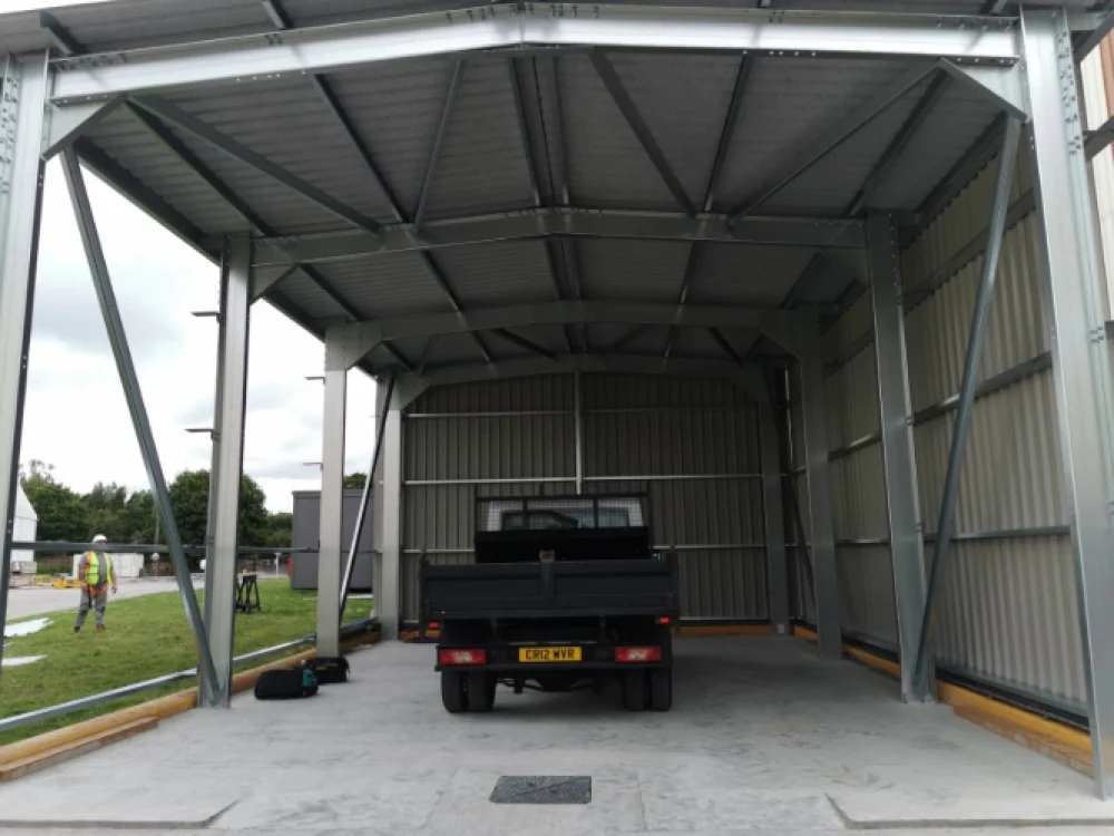Steel canopy shelter with vehicle parked underneath