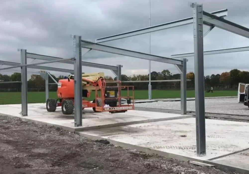 Steel portal frame erected on a concrete base beside a football pitch for the Welsh Football Association