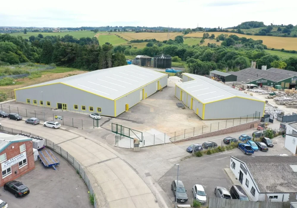 Aerial view of two refurbished industrial units in Yeovil with new grey roof sheeting and yellow trim